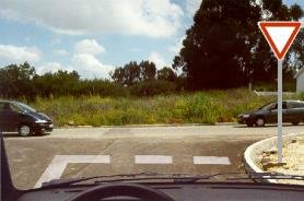 Give way sign with shark teeth road markings at a junction