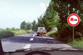 No overtaking for heavy vehicles sign with a truck ahead
