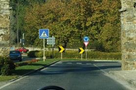 Roundabout entry with pedestrian crossing sign and chevron markers