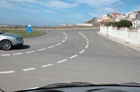 Silver car entering a roundabout from the left