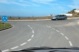 Estate car circulating in a roundabout, roundabout sign at left
