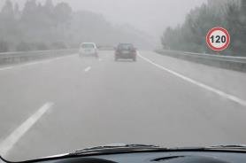 Foggy motorway with a 120 speed limit sign