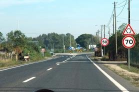 Roundabout approach warning triangle mounted above a 70 limit sign