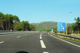 Blue sign showing a lane merging on a dual carriageway